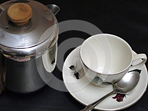 An empty cup and saucer and teapot