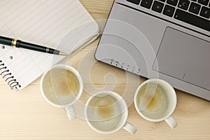Empty cups of espresso / coffee in front of a laptop
