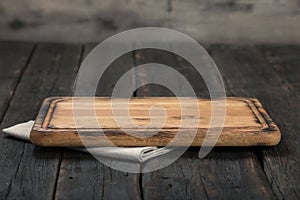 Empty cutting board with cloth napkin on wooden table