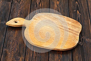 Empty cutting board on a dark wooden table