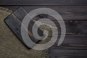 Empty cutting board on a dark wooden table. Top view