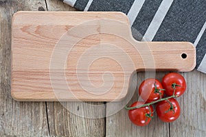 empty cutting board and tomatoes on old wooden planks, background