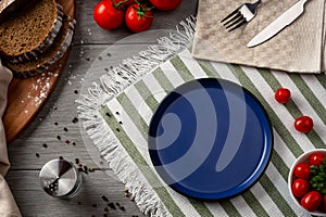 An empty dark blue plate as serving on the table.