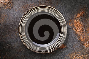 Empty dark brown plate on the table, top view. Food background