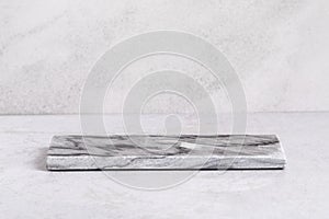 Empty dark marble podium for product display on gray background