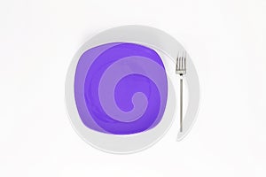 Empty Dark Violet Purple color plate and fork next to it. Isolated object - on white background.