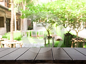 Empty Dark wood table top with blur on green garden or tree in tropical abstract background