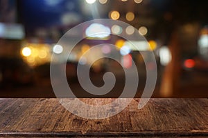 Empty dark wooden table in front of abstract blurred bokeh background of restaurant.