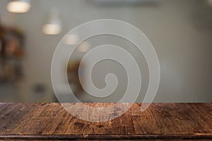 Empty dark wooden table in front of abstract blurred bokeh background of restaurant.