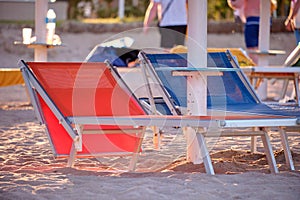 Empty deck chairs on sandy beach sea side in summer resort. Vacations and getaway concept