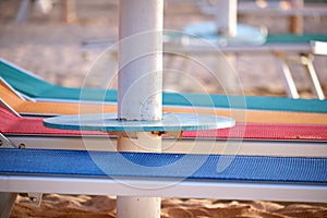 Empty deck chairs on sandy beach sea side in summer resort. Vacations and getaway concept