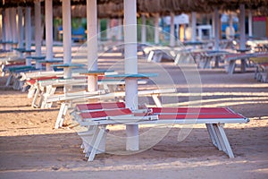 Empty deck chairs on sandy beach sea side in summer resort. Vacations and getaway concept