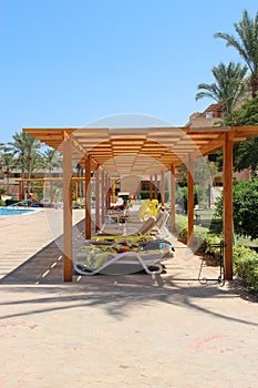 Empty deck chairs with towels on tropical resort beach. Pair of chaise longues