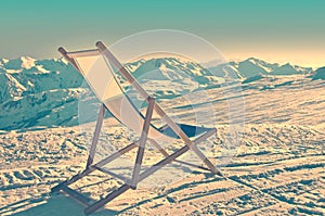 Empty deckchair on the side of a ski slope, vintage