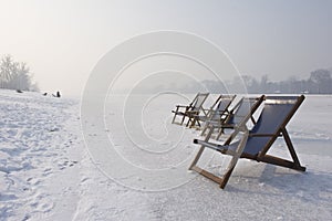 Empty deckchairs on frozen lake