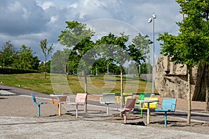 Empty and deserted, colorful chairs and tables outdoors in a park, playground.