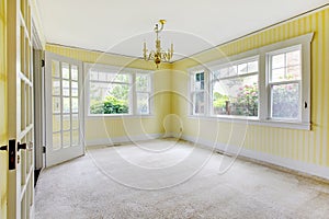 Empty dinning room with cream carpet and yellow walls.