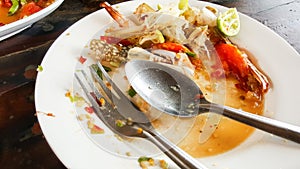 Empty dirty plate seafood paste on wooden table left after lunch