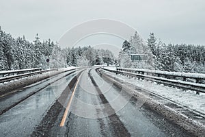 An empty, dirty winter highway. A turn on a slippery road