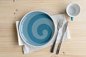 Empty dish with knife and fork on old wooden background