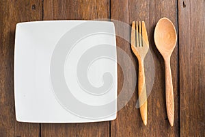 Empty dish, Wooden spoon and fork on wooden background