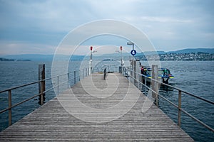 Empty dock with ferry boat at Limmat river with cloudy sky