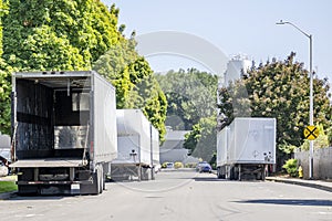 Empty dry van semi trailers with open back door standing on the street in industrial area waiting for loading time