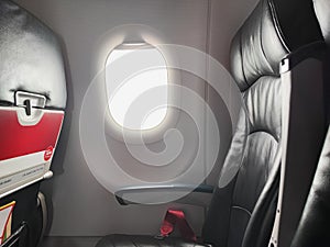 Empty economy seat on a plane as the COVID-19 pandemic ravages travel and business aviation. Travel concept. Focus window with