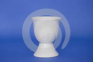 An empty egg cup on a blue background
