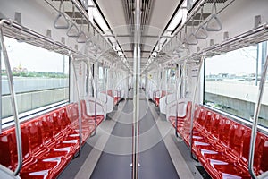 Empty elevated train coach with red seats