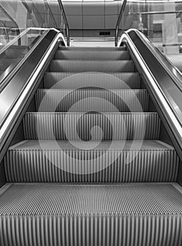 Empty escalator in the airport monochrome. Escalator in subway black and white. Electric staircase in perspective.