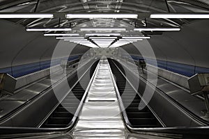 Empty escalator stairs in a train station, seen from above. Up and down