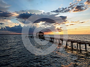 Fishing pier and dock silhouetted in a colorful sunset