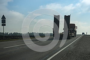 Empty flatbed platform truck with lowbed semi-trailer road rear side view