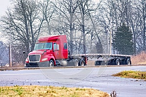 An Empty Flatbed Tractor Trailer Drives in Mixed Winter Weather