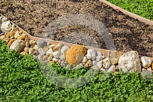 Empty flower bed propped with stones photo