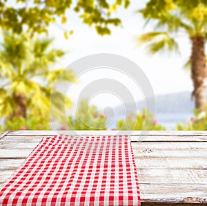 Empty food table,red tableclothes on blurred summer park background, copy space