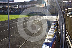 An empty football field. Soccer field grass. Graphite running road track with white marking lines near green football