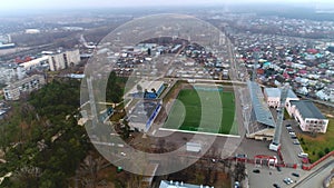 Empty football field at stadium in city aerial panorama