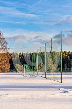 Empty Football (Soccer) Field in the Winter Partly Covered in Snow - Sunny Winter Day