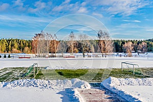 Empty Football (Soccer) Field in the Winter Partly Covered in Snow - Sunny Winter Day