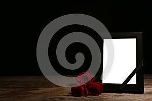 Empty frame with black ribbon and roses
