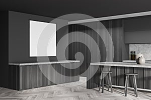 Empty frame on dark grey wall in minimalist kitchen. Corner view