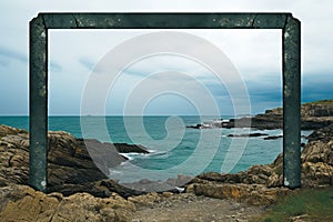 an empty frame on a rocky beach with the ocean in the background