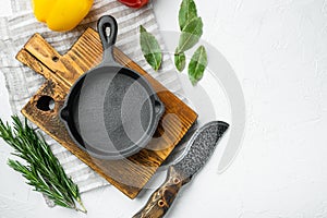 Empty frying cast iron pan background, kitchenware cooking concept, on white stone  surface, top view flat lay, with copy space