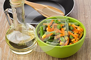 Empty frying pan, bottle of oil and frozen vegetable mix