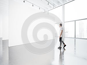 Empty gallery interior with white canvas and young