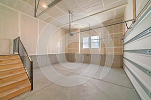 Empty garage interior with wooden stairs and windows