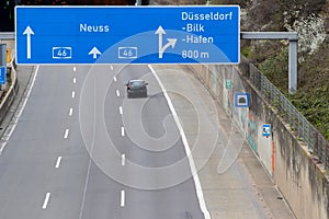 Empty German Autobahn in Dusseldorf with blue street signs and white arrows without traffic jam shows multiple lane highway ready