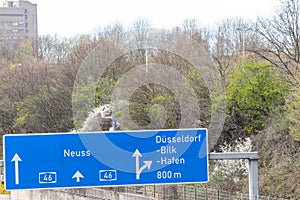 Empty German Autobahn in Dusseldorf with blue street signs and white arrows without traffic jam shows multiple lane highway ready